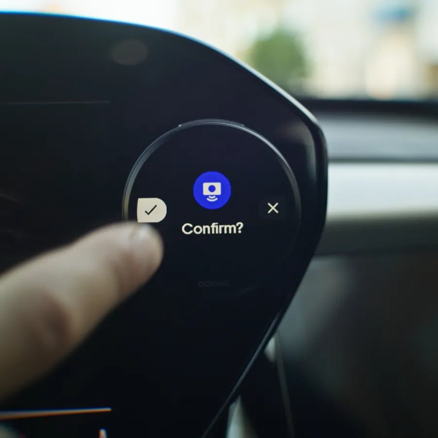 Driver confirming a warning on the device with a thumb